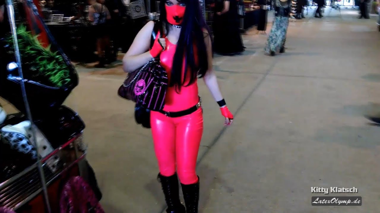Latex Girl with pink rubber catsuit, gloves, mask and fashionable boots shopping in Agra mall on WGT